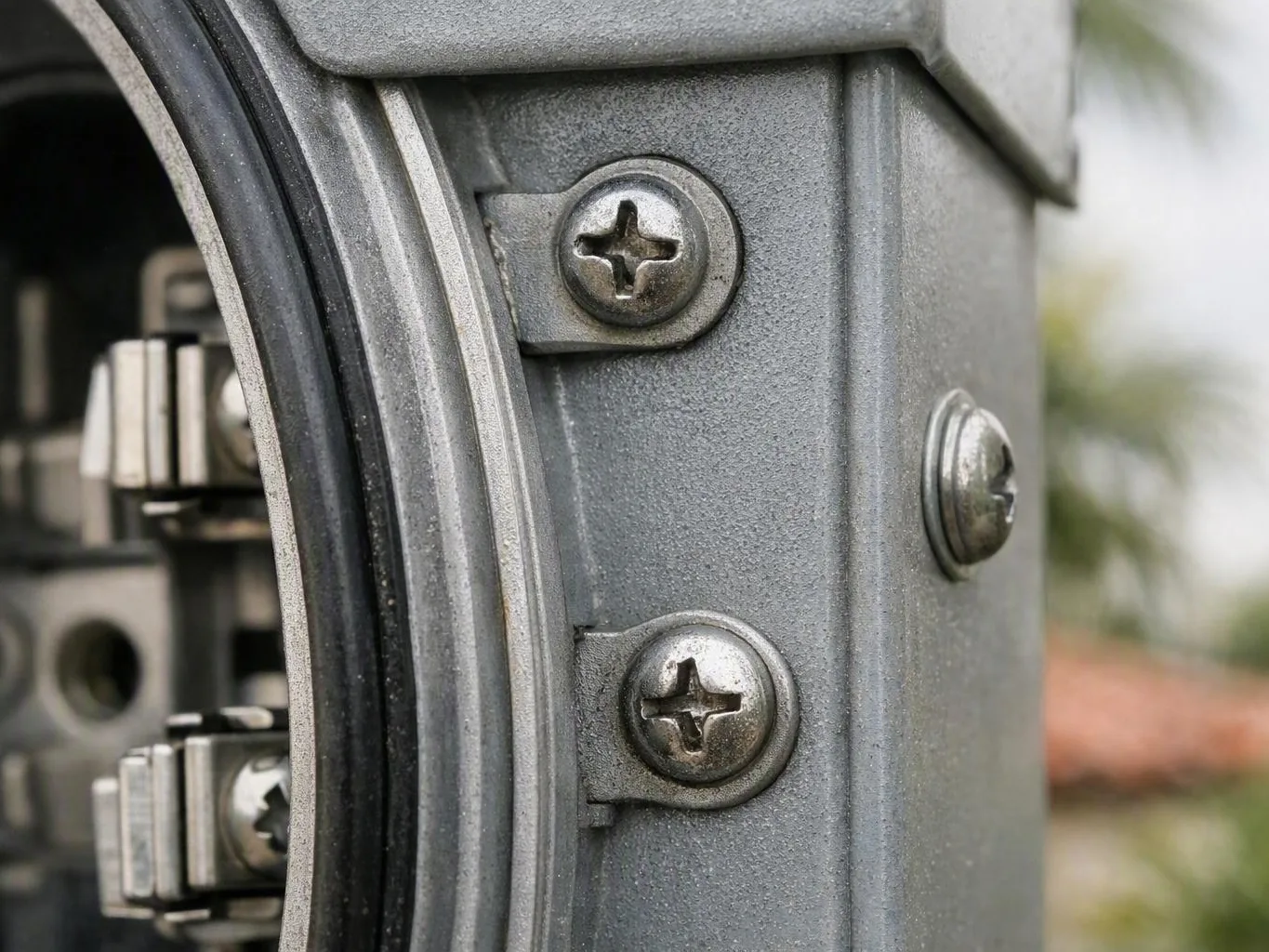Close-up of silver electrical hardware with Phillips screws attached to a
